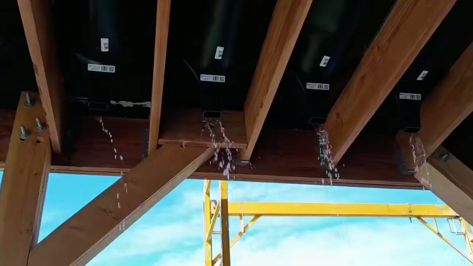 Water pouring out of under-deck drainage downspouts during the leak test of the new deck