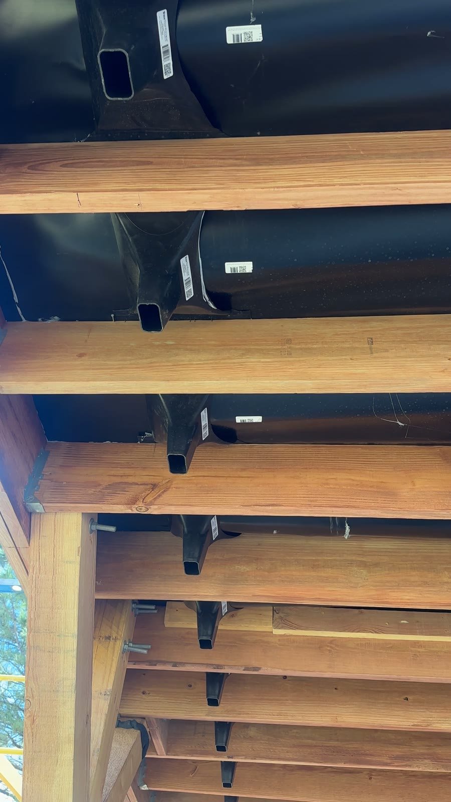 Trex RainEscape under-deck drainage membrane troughs and downspouts installed between deck joists