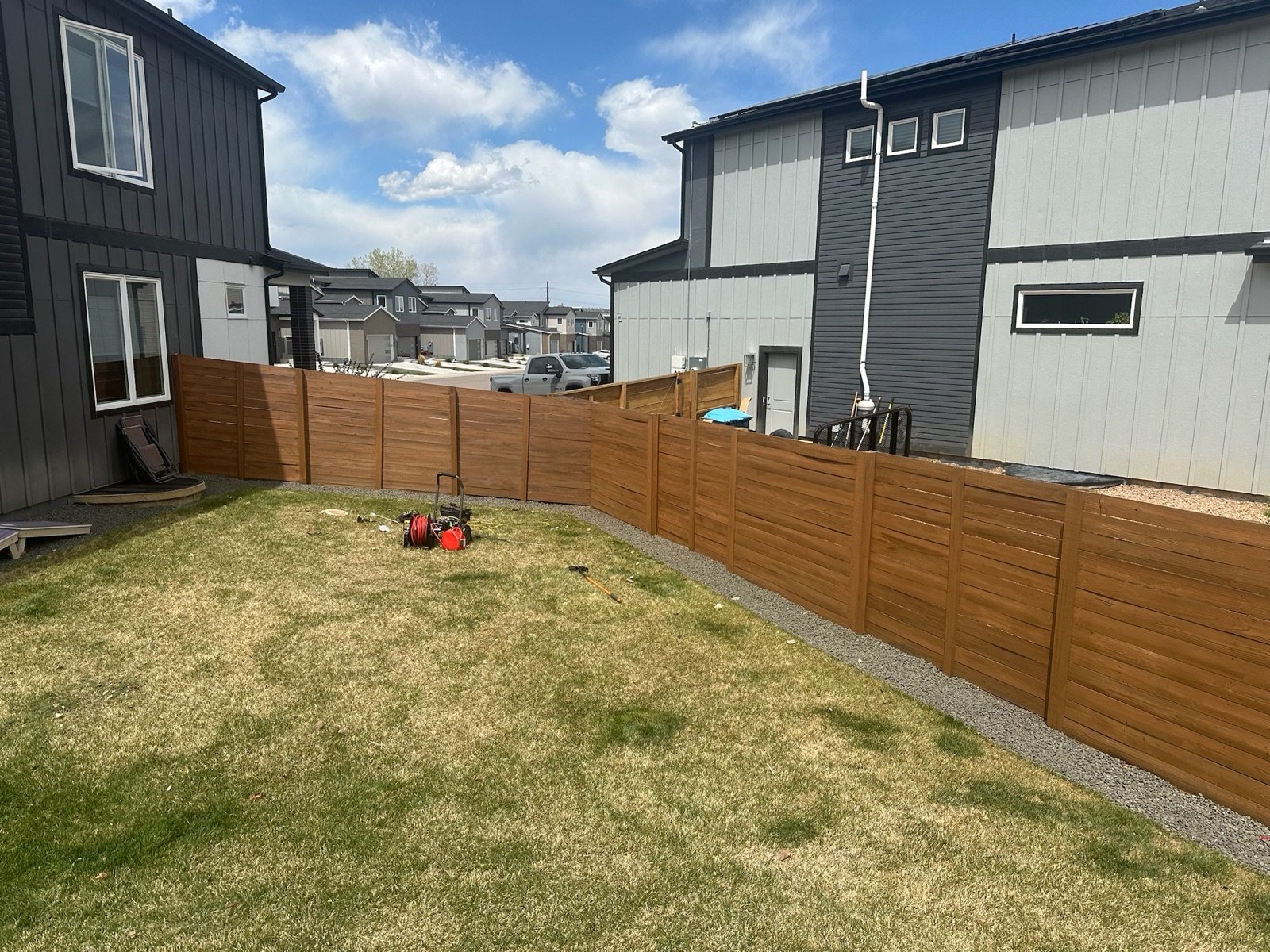 Freshly stained backyard fence in full Colorado sun