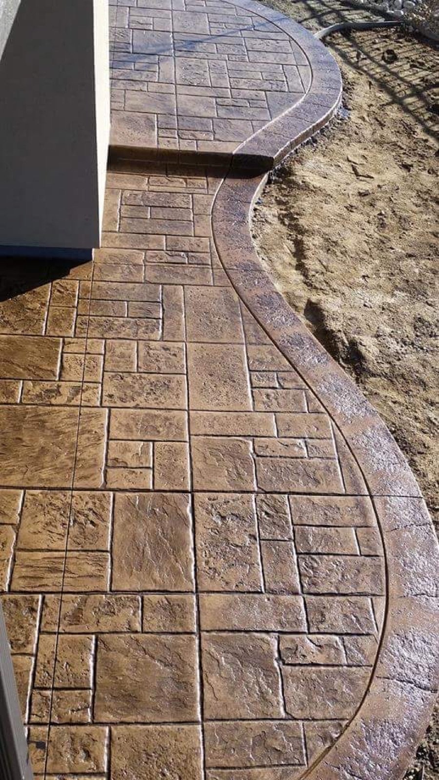 Stamped and sealed concrete walkway with a curved border